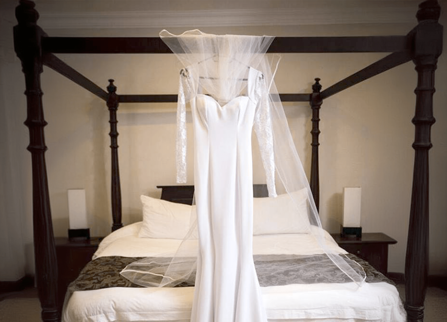 A wedding dress hanging on the four-poster bed in the bridal suite at Usambara Lodge