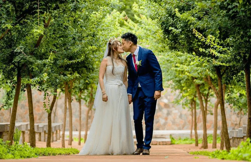 A couple among the trees of the Forest Chapel at Usambara Venue