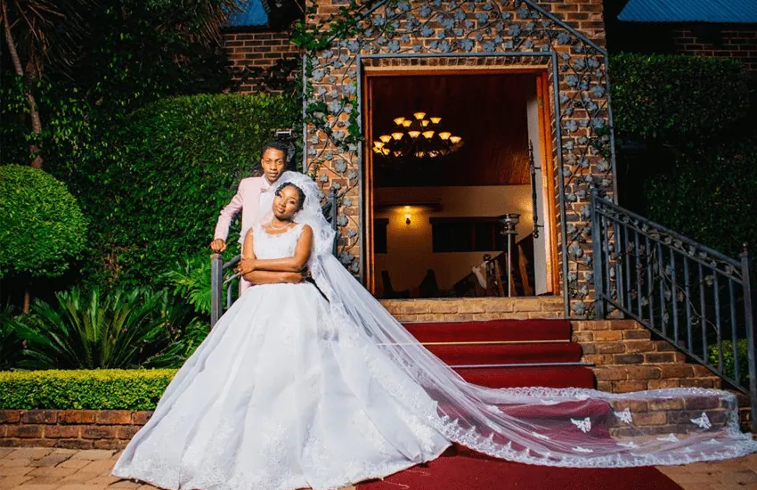 A bride and groom on the stone steps of the Formal Chapel at Usambara Venue