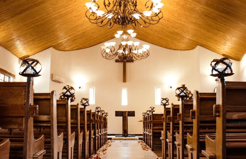 Inside the Formal Chapel at Usambara Venue, with wooden pews beneath a timber ceiling and chandelier