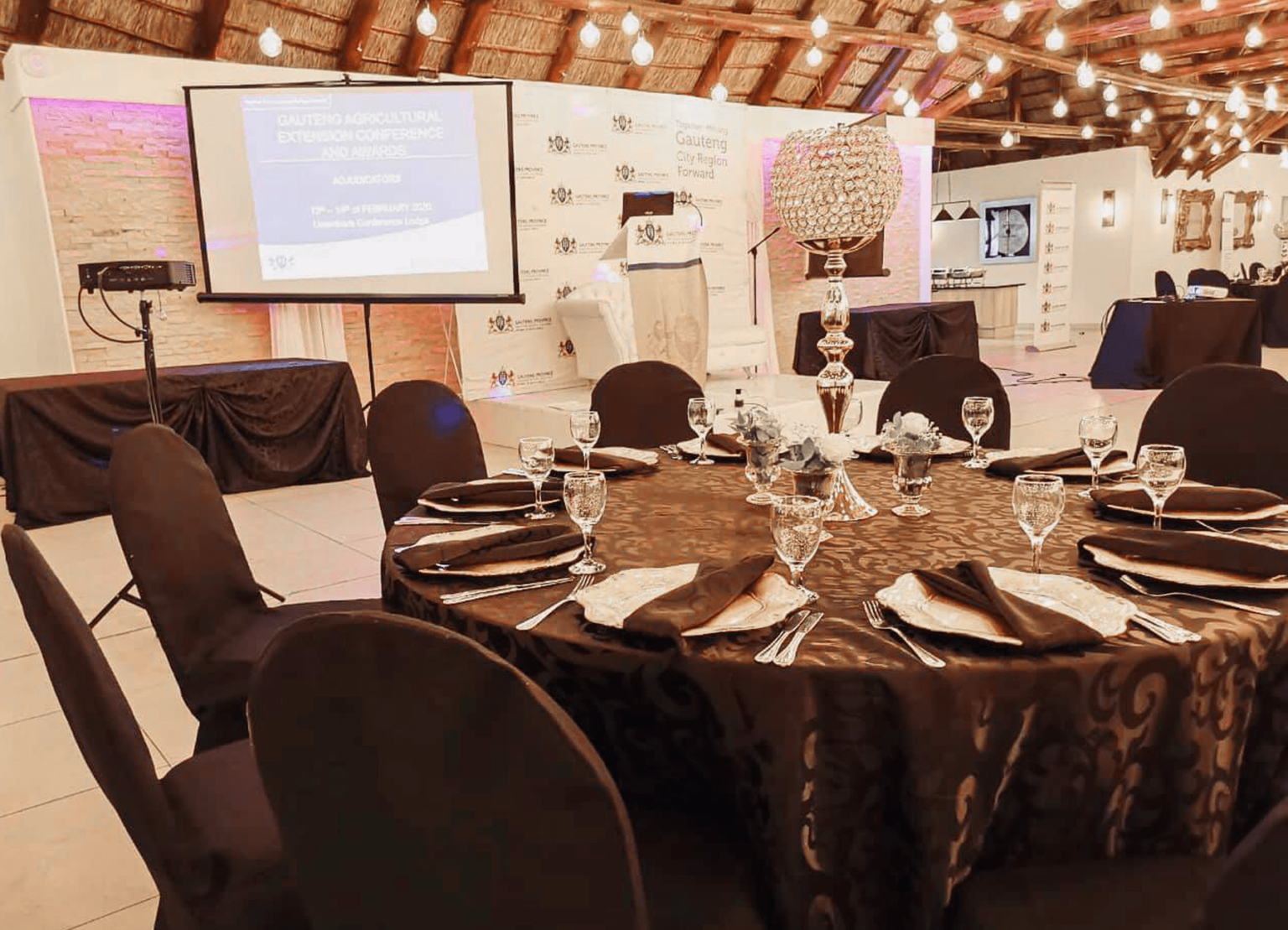 Round tables and a presentation screen in the conference venue at Usambara Venue