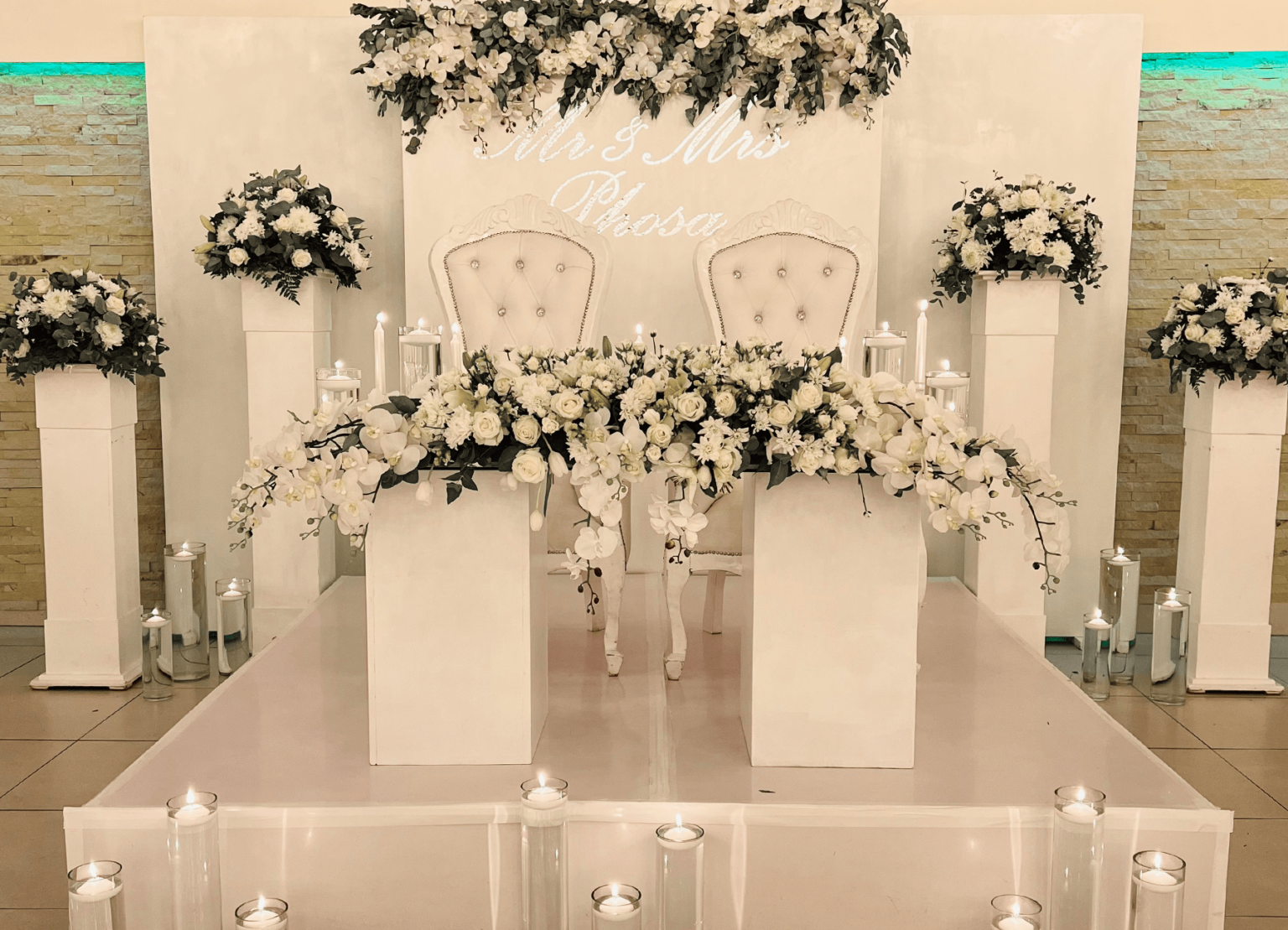 A white floral bridal table backdrop at Usambara Venue