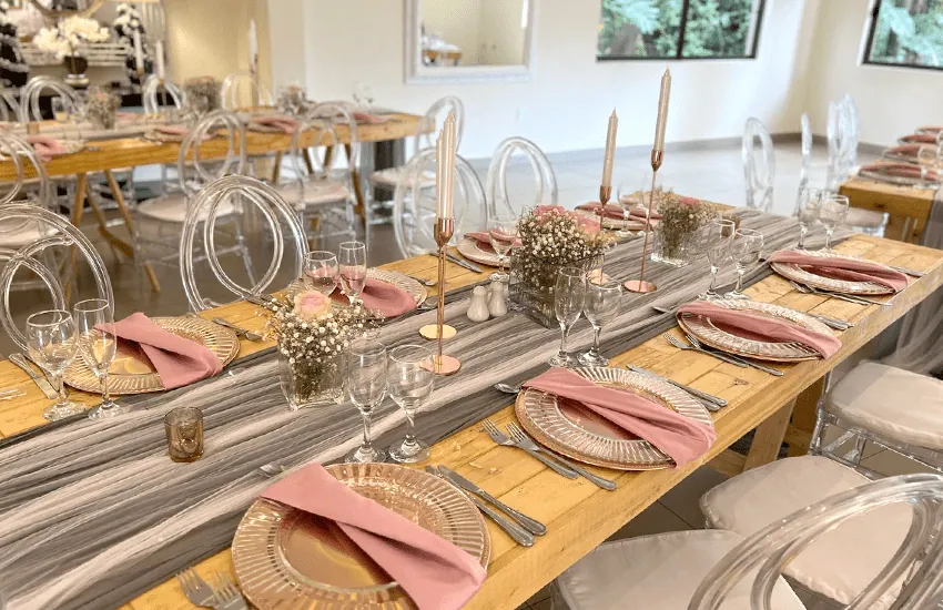 A long table set with dusty pink napkins in the Mabweni venue at Usambara Venue