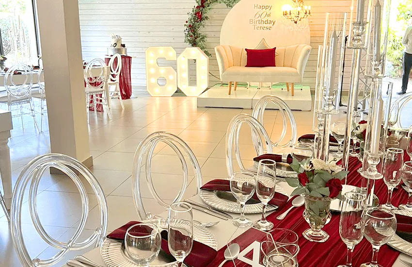 A burgundy and gold 50th celebration setup in the Mabweni venue at Usambara Venue