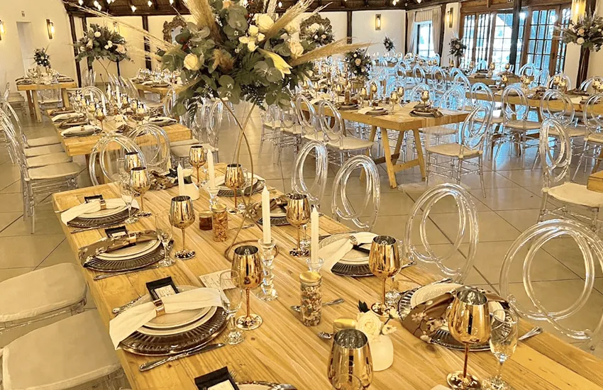 Wooden banquet tables with gold detailing in the Mponde venue at Usambara Venue