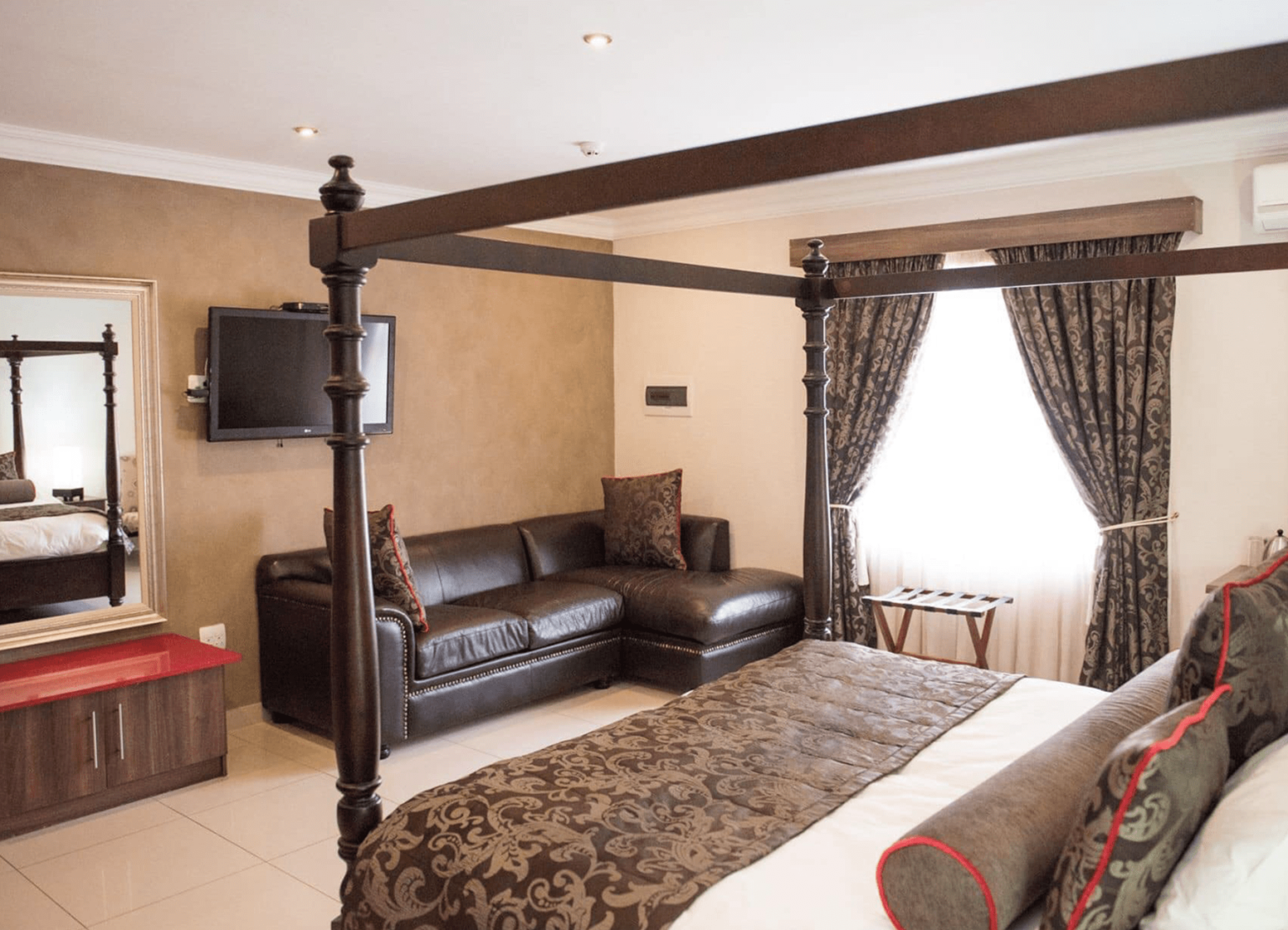 A luxury double room with a four-poster bed at Usambara Lodge