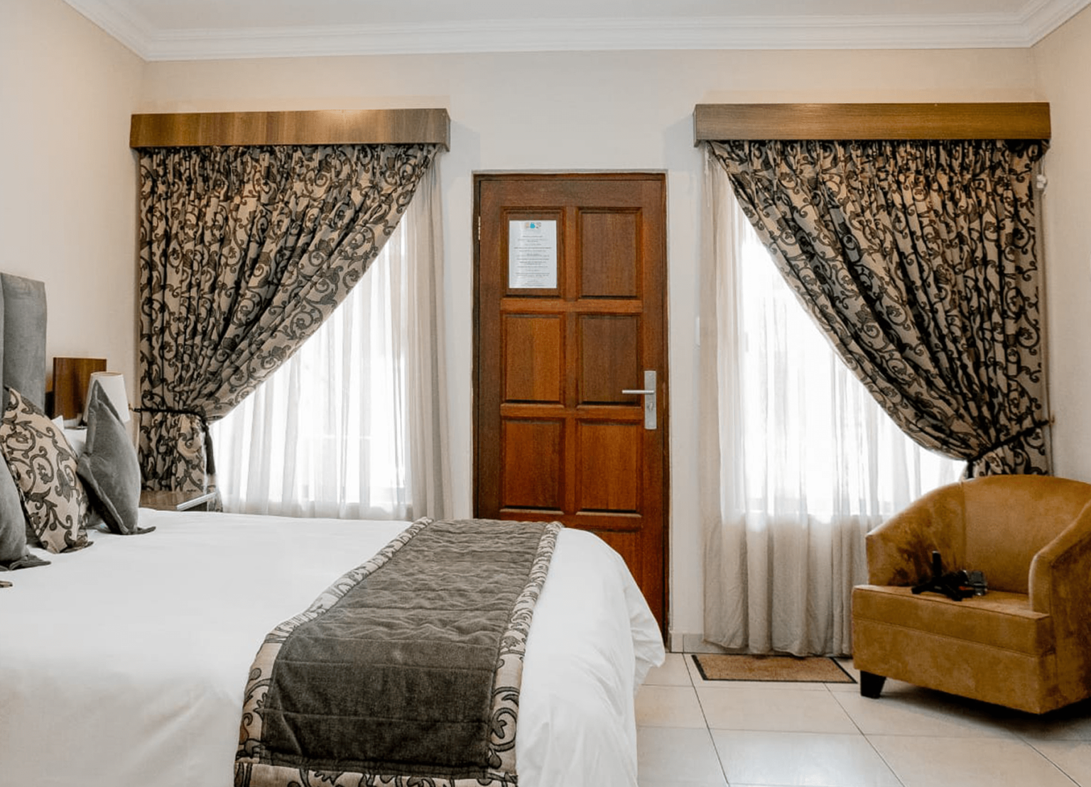 A double bedroom with garden-facing windows at Usambara Lodge