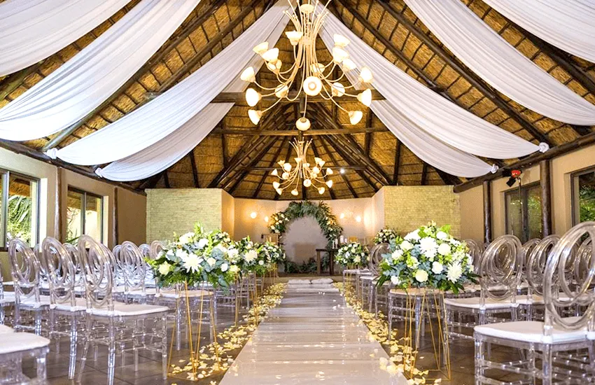 Inside the Amani Chapel at Usambara Venue, with a draped ceiling and chandelier above a petal-strewn aisle