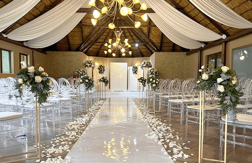 Tall white floral arrangements along the Amani Chapel aisle at Usambara Venue